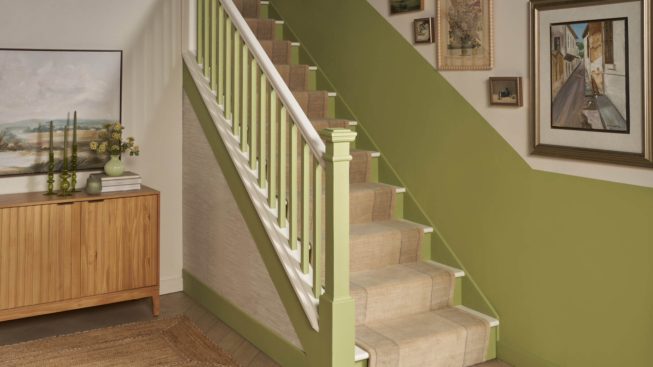 Staircase with a beige runner and green painted accents on both sides of the stairs