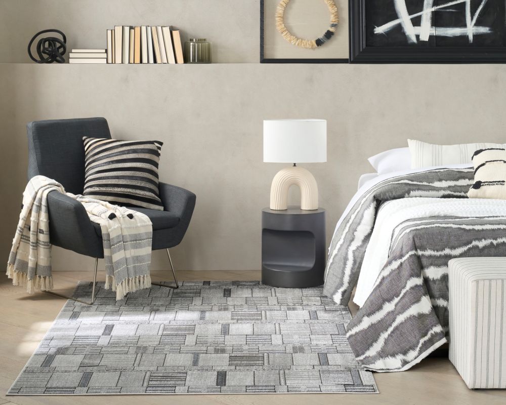 Bedroom in black and grey monochrome with an abstract geometric rug