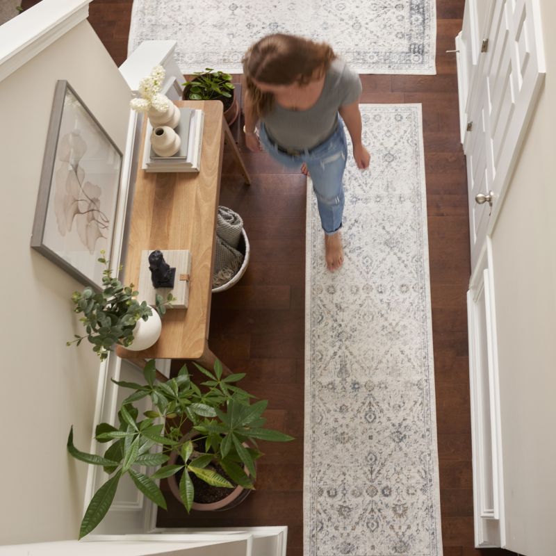 Woman walking down the hallway with a vintage-style runner on the floor