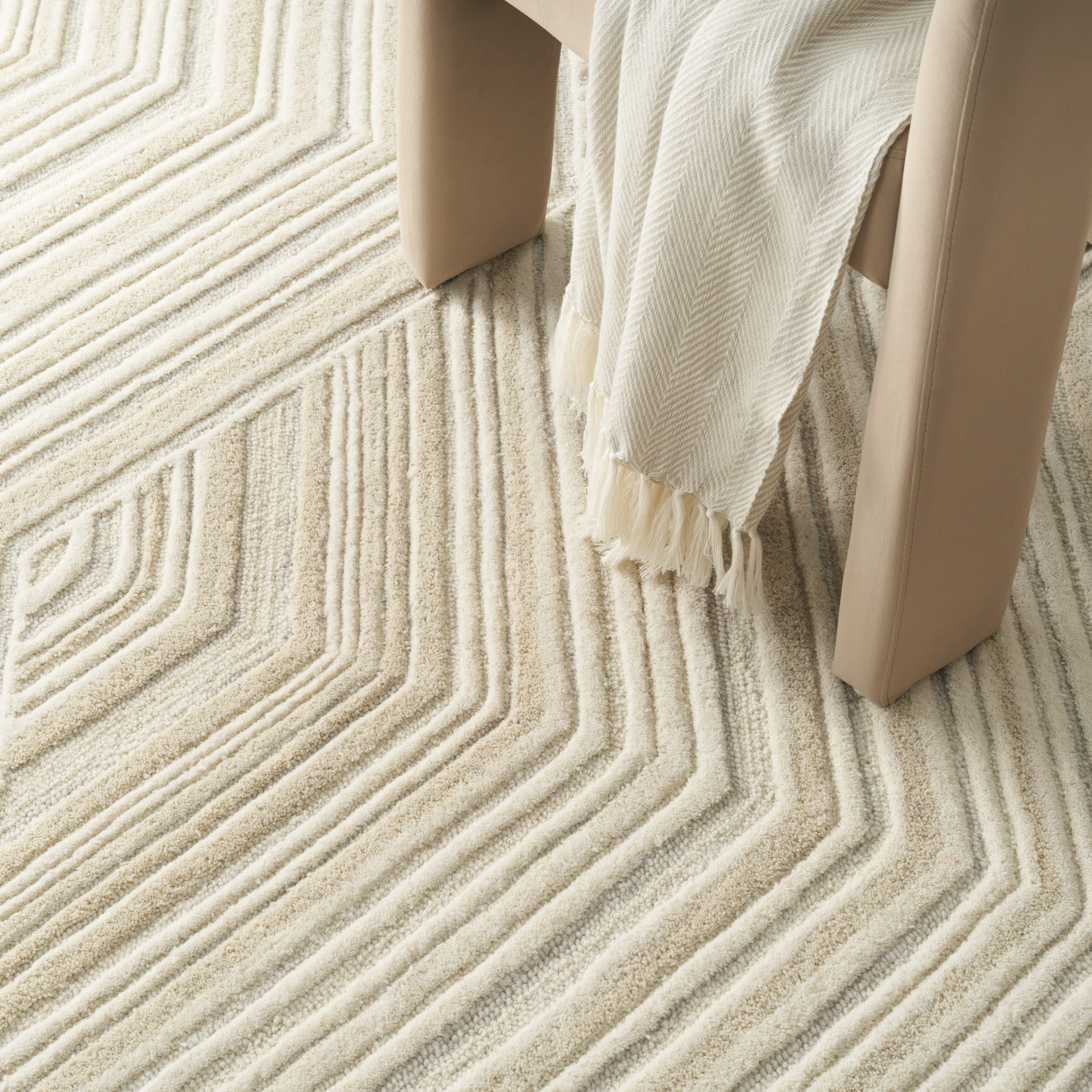 Graceful GRU03 ivory area rug in a neutral living room with white armchairs, wooden console table, and olive tree