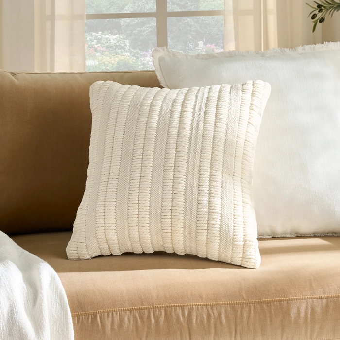Mina Victory Lifestyle GC965 ivory woven stripe throw pillow on a camel upholstered sofa with white pillow backdrop