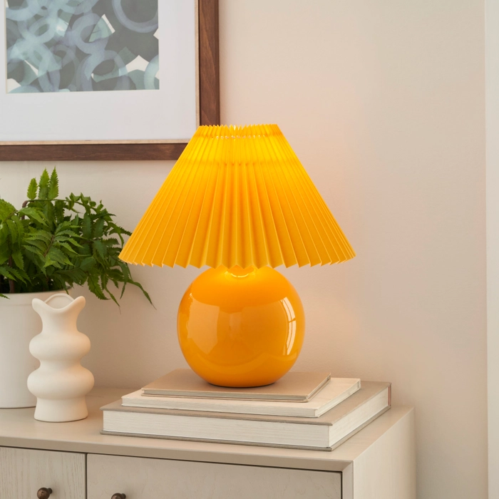 13-inch WDL07 orange ceramic accent lamp with pleated shade on a light dresser beside a potted fern and white ceramic vase